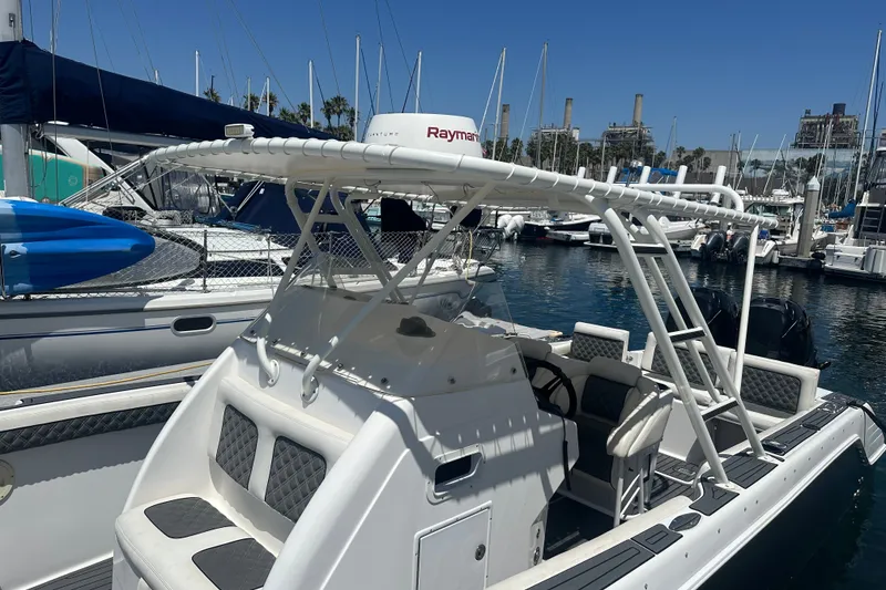 Slide: The Image of 2007 Donzi 35 ZF Cuddy boat docked in a marina, featuring a sleek design and spacious seating. - 12