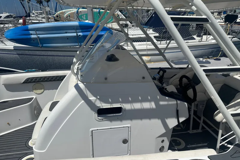 Slide: The Image of 2007 Donzi 35 ZF Cuddy boat interior with steering wheel, docked near other vessels. - 10