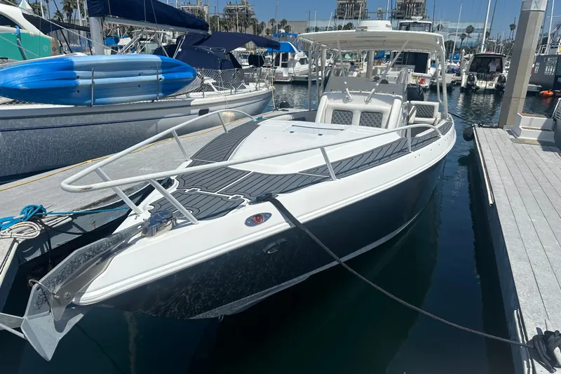 Slide: The Image of 2007 Donzi 35 ZF Cuddy boat docked in a marina, featuring sleek design and spacious deck. - 4