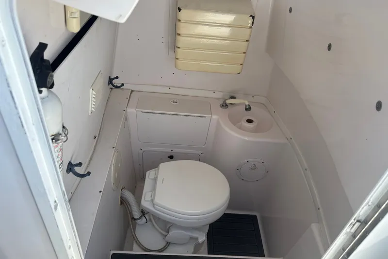 Slide: The Image of 2007 Donzi 35 ZF Cuddy boat bathroom with toilet, sink, and fire extinguisher. - 16
