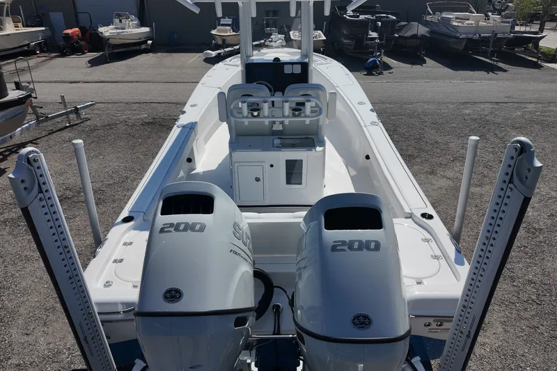 Slide: The Image of 2027 Blazer Bay Makaira 2800 boat with dual Suzuki 200 engines, docked outdoors. - 18