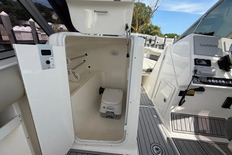 Slide: The Image of 2025 Key West 239 DFS boat interior with open storage compartment and Garmin navigation system. - 19