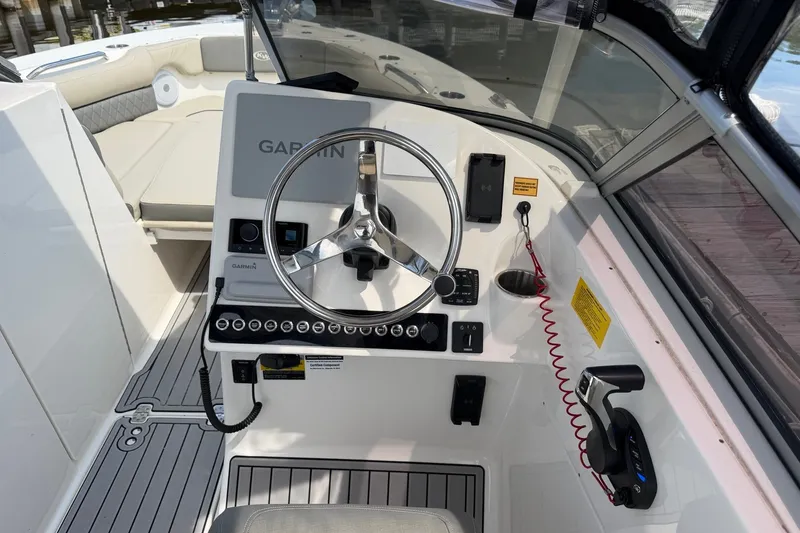 Slide: The Image of 2025 Key West 239 DFS boat dashboard with Garmin navigation system and steering wheel. - 17