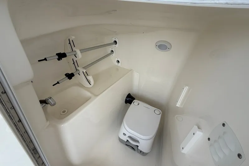 Slide: The Image of Interior of 2025 Key West 239 DFS boat with compact toilet and storage area. - 20