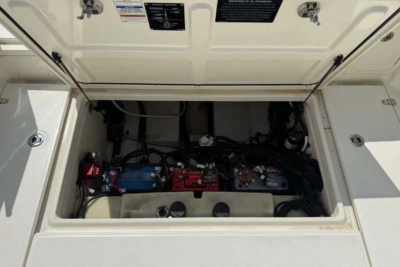 Slide: The Image of 2020 Boston Whaler 285 Conquest engine compartment with batteries and wiring visible. - 16