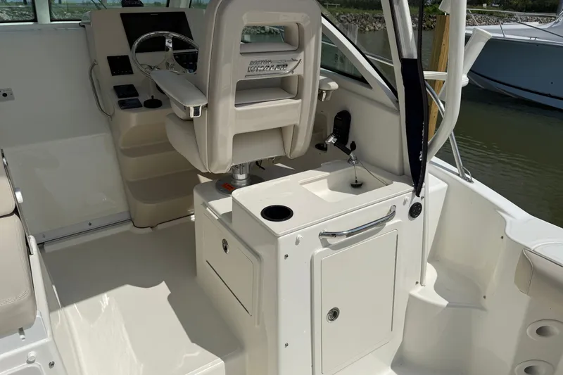 Slide: The Image of Interior of a 2020 Boston Whaler 285 Conquest boat, featuring helm and seating area. - 15
