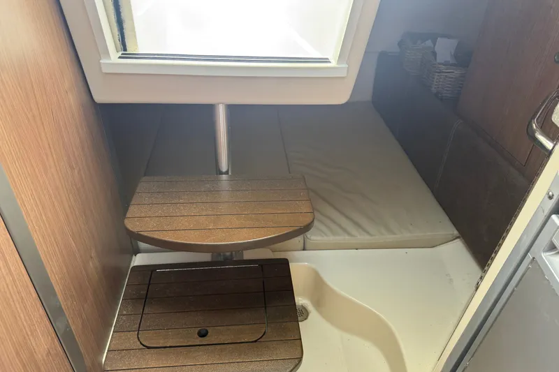 Slide: The Image of Interior cabin of 2020 Boston Whaler 285 Conquest with wooden steps and seating area. - 9