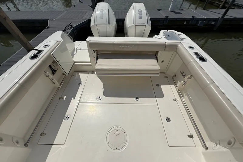 Slide: The Image of 2020 Boston Whaler 285 Conquest boat deck with seating and twin outboard engines. - 2