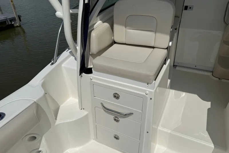 Slide: The Image of 2020 Boston Whaler 285 Conquest boat interior with cushioned seat and storage drawers. - 14