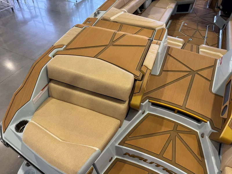 Slide: The Image of The image shows the luxurious deck of a 2026 Nautique Super Air Nautique G25 Paragon with beige upholstery and elegant wood accents. - 13