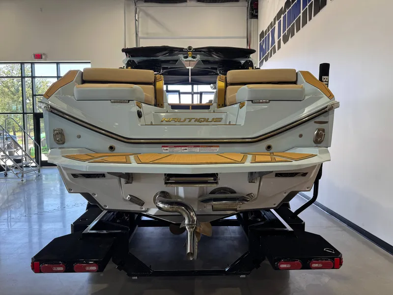 Slide: The Image of The image shows the rear of a 2026 Nautique Super Air Nautique G25 Paragon in a showroom. - 7