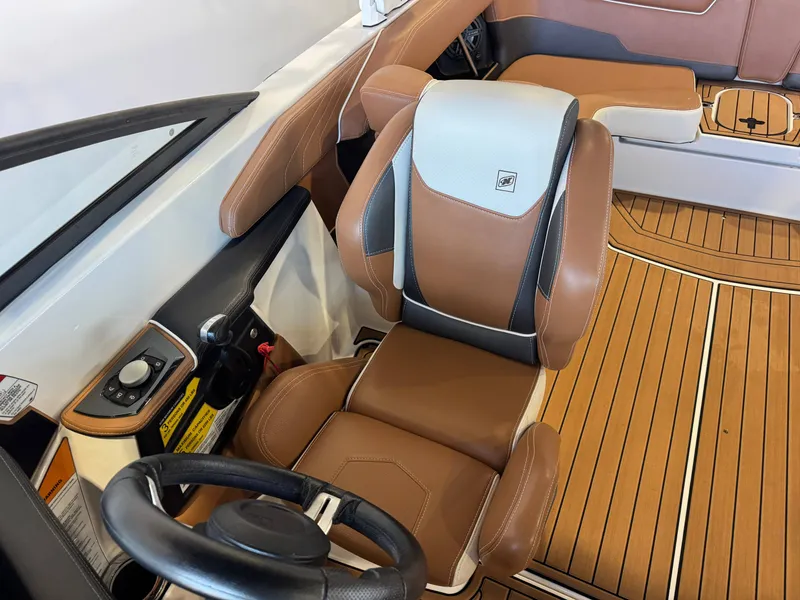 Slide: The Image of The image shows the interior of a 2018 Nautique Super Air Nautique GS22 with brown leather seats and wood flooring. - 21