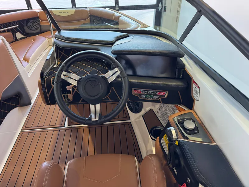 Slide: The Image of The image shows the cockpit of a 2018 Nautique Super Air Nautique GS22 with a modern steering wheel and digital display. - 26