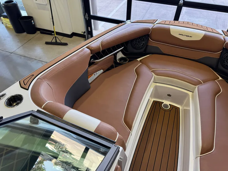 Slide: The Image of The image shows the bow area of a 2018 Nautique Super Air Nautique GS22 with brown upholstery. - 19
