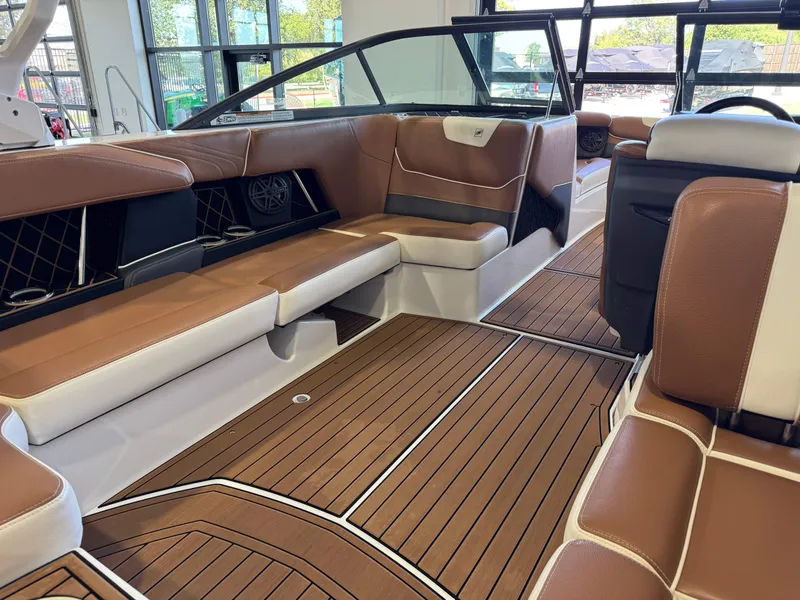 Slide: The Image of The image shows the interior of a 2018 Nautique Super Air Nautique GS22 with brown leather seats and wood flooring. - 14