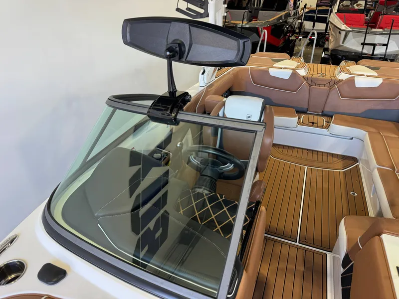 Slide: The Image of The image shows the cockpit of a 2018 Nautique Super Air Nautique GS22 with brown leather seats. - 20