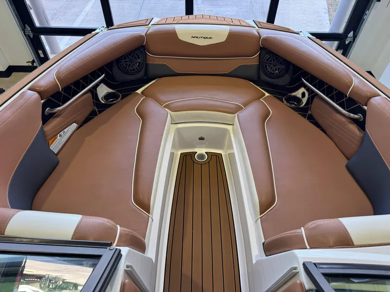 Slide: The Image of The image shows the bow area of a 2018 Nautique Super Air Nautique GS22 with brown upholstery. - 17