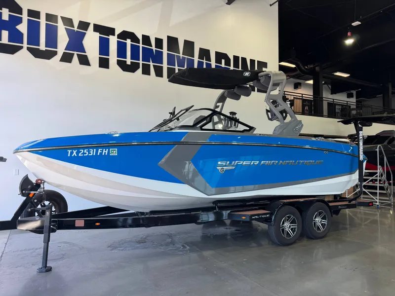 Slide: The Image of A blue and white 2020 Super Air Nautique G23 on a trailer in a showroom. - 3