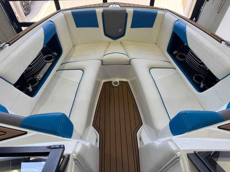 Slide: The Image of The image shows the bow area of a 2020 Super Air Nautique G23 with white and blue upholstery. - 17