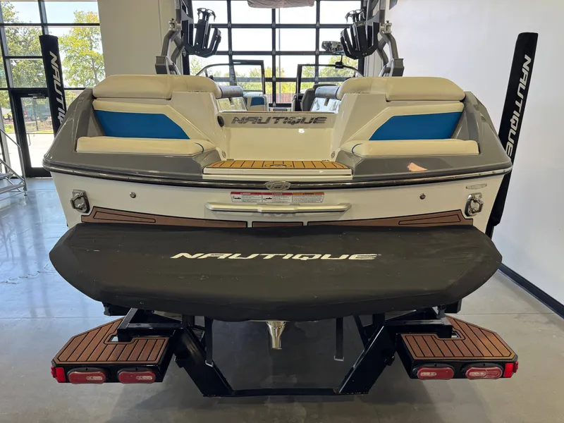Slide: The Image of The image shows the rear of a 2020 Super Air Nautique G23 boat in a showroom. - 8