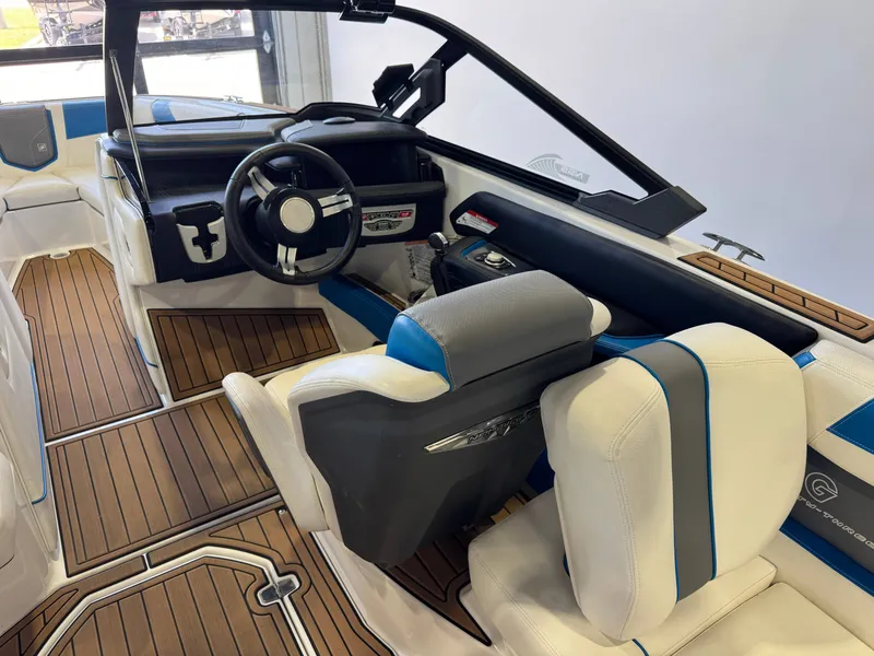 Slide: The Image of The image shows the cockpit of a 2020 Nautique Super Air Nautique G23 with white and blue seats. - 24