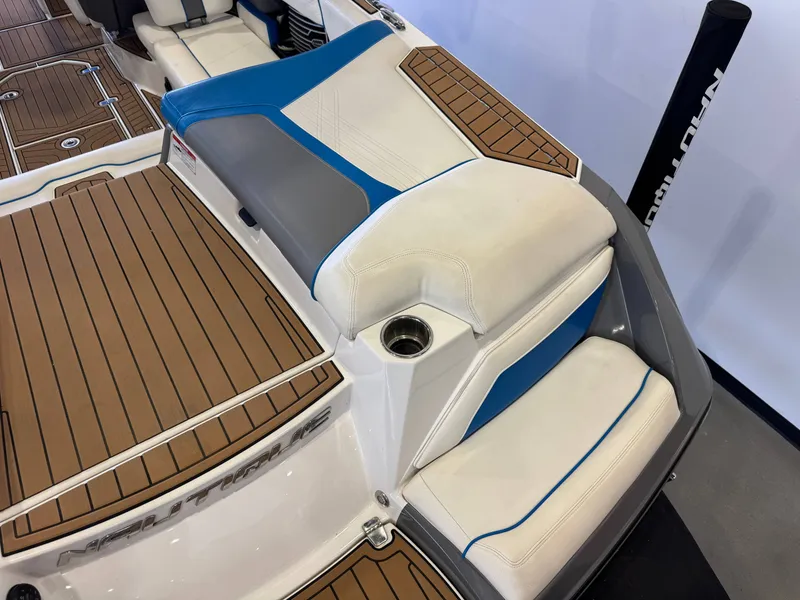 Slide: The Image of The image shows the stern of a 2020 Nautique Super Air Nautique G23 with cushioned seats and teak-style flooring. - 11