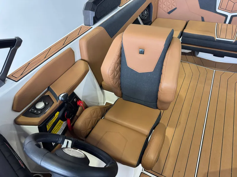 Slide: The Image of The image shows the interior of a 2026 Nautique Super Air Nautique GS22 with brown leather seats and a modern helm area. - 21
