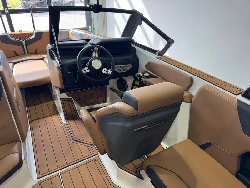 Slide: The Image of The image shows the interior of a 2026 Nautique Super Air Nautique GS22 with sleek brown seating and a modern helm. - 24