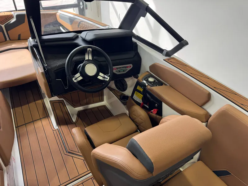 Slide: The Image of The image shows the cockpit of a 2026 Nautique Super Air Nautique GS22 with brown leather seats. - 25