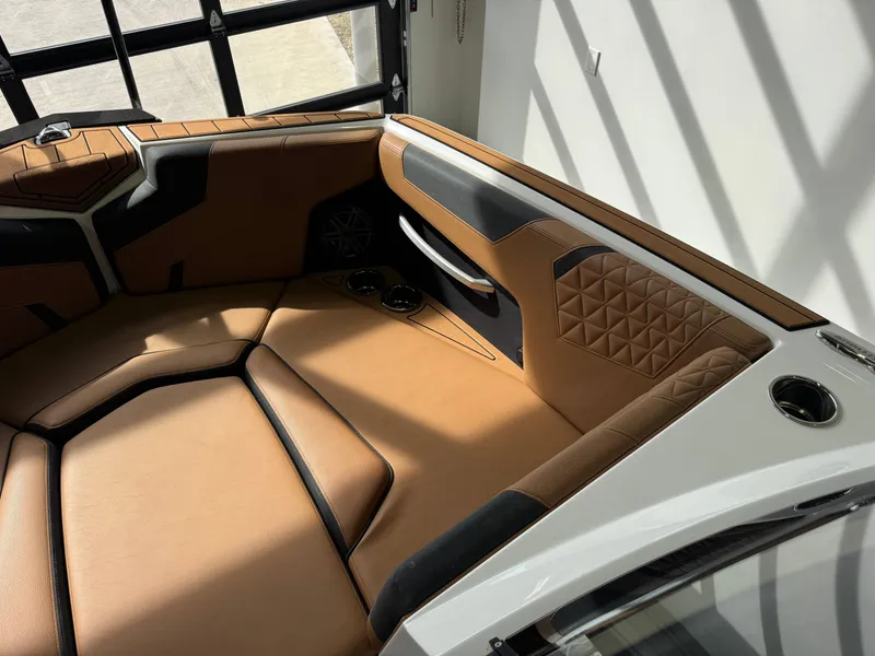 Slide: The Image of The image shows the interior of a 2026 Nautique Super Air Nautique GS22 with sleek brown upholstery. - 18