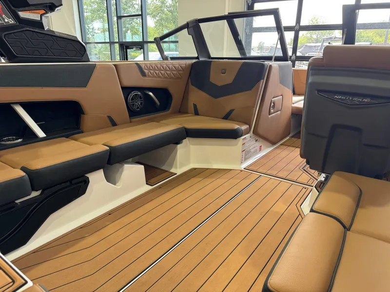 Slide: The Image of Interior of a modern boat with brown and black seating, wood flooring, and large windows. - 14