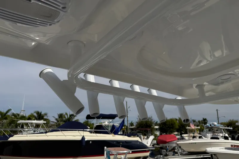 Slide: The Image of Rod holders on a 2026 Sea Pro 245FLXR Sandbar boat, docked with other vessels. - 31