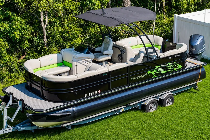 Slide: The Image of 2018 Starcraft SLS 5 Q pontoon boat on trailer, featuring sleek design and comfortable seating. - 12