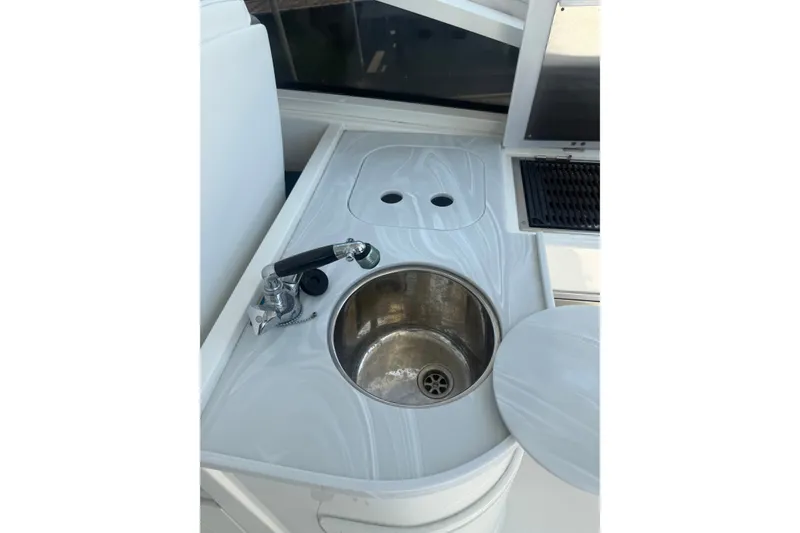 Slide: The Image of 2022 World Cat 325 DC boat sink and faucet in sleek white countertop. - 9