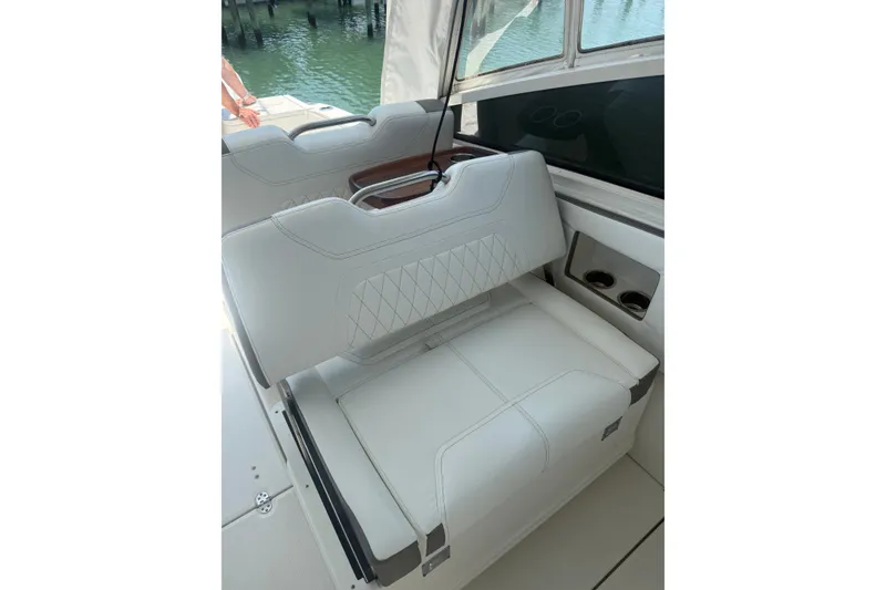 Slide: The Image of Luxury seating on 2022 World Cat 325 DC boat, featuring white upholstery and cup holders. - 7