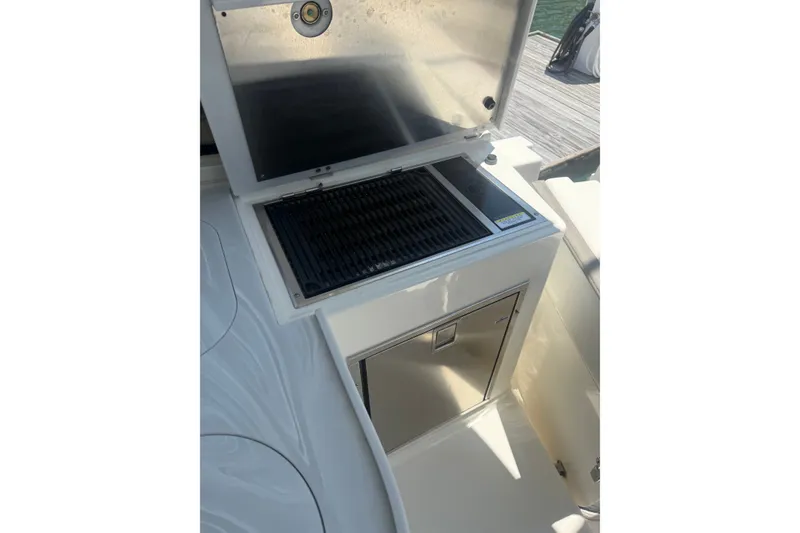 Slide: The Image of Outdoor grill station on 2022 World Cat 325 DC boat, featuring stainless steel components. - 8