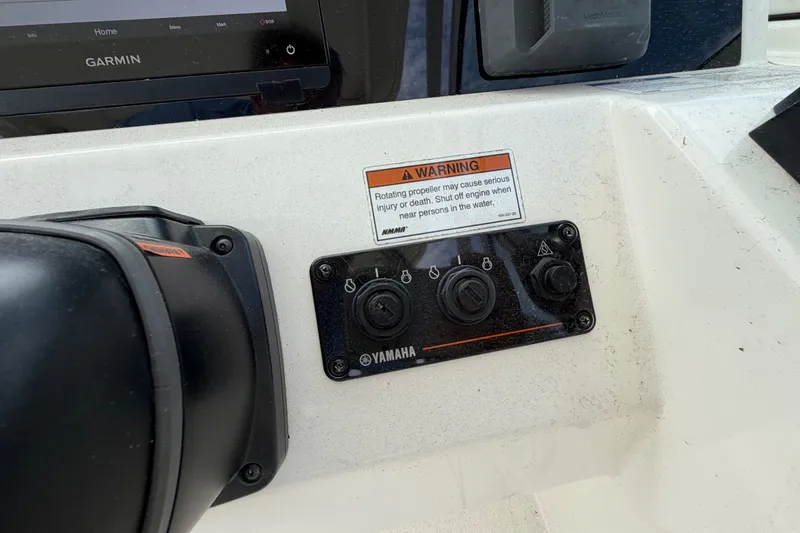 Slide: The Image of Control panel of 2022 World Cat 230 DC boat with Yamaha switches and Garmin display. - 43