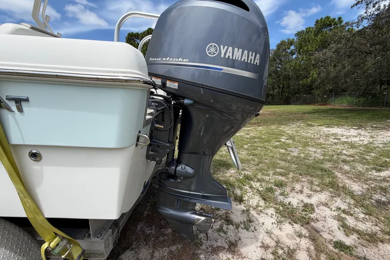 Slide: The Image of 2022 World Cat 230 DC boat with Yamaha four-stroke outboard motor in a grassy area. - 22