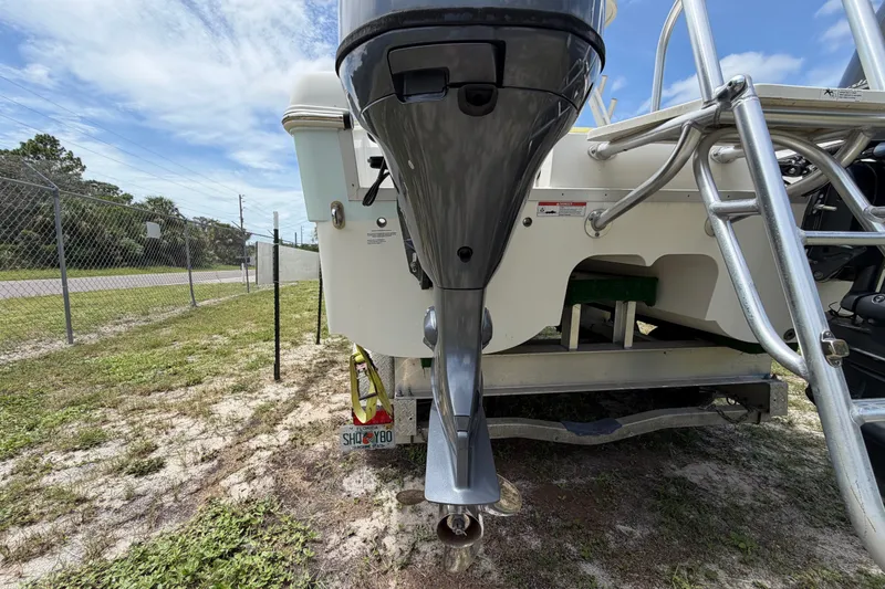 Slide: The Image of 2022 World Cat 230 DC boat with outboard motor and ladder, parked on grass. - 19
