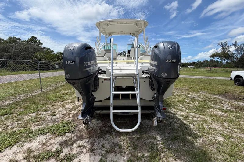 Slide: The Image of 2022 World Cat 230 DC boat with dual Yamaha 115 engines, parked on grass. - 29