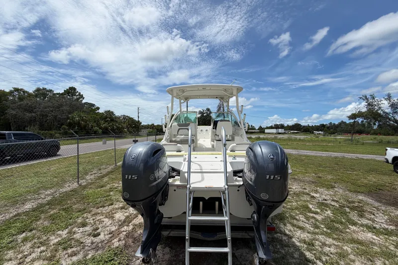 Slide: The Image of 2022 World Cat 230 DC boat with twin Yamaha 115 engines, parked outdoors under a blue sky. - 31