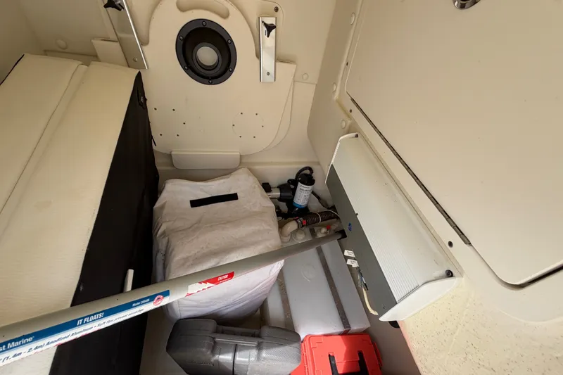 Slide: The Image of Storage compartment of 2022 World Cat 230 DC boat with various equipment and supplies. - 58