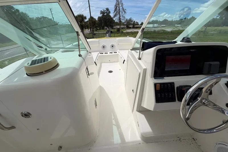 Slide: The Image of 2022 World Cat 230 DC boat interior with steering wheel and dashboard controls. - 56
