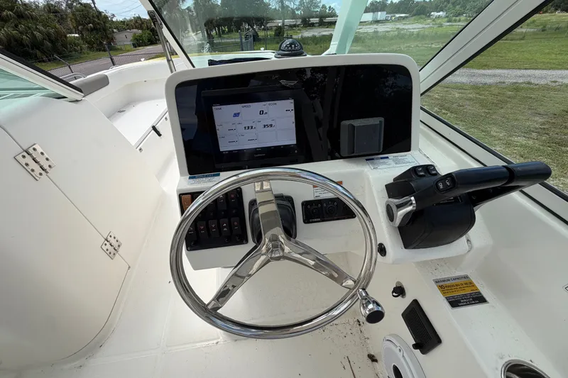 Slide: The Image of 2022 World Cat 230 DC boat helm with steering wheel and control panel. - 40