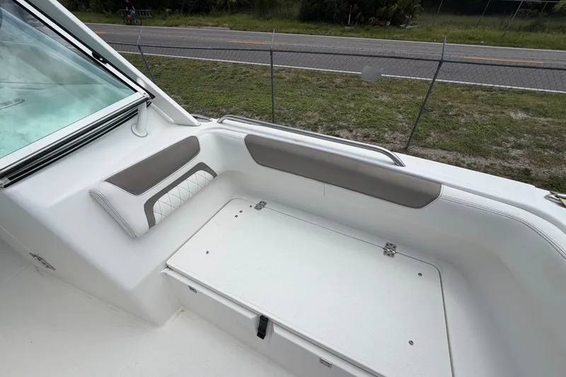 Slide: The Image of 2022 World Cat 230 DC boat interior with cushioned seating and storage compartment. - 68