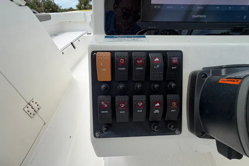 Slide: The Image of Control panel of a 2022 World Cat 230 DC boat with various switches. - 42