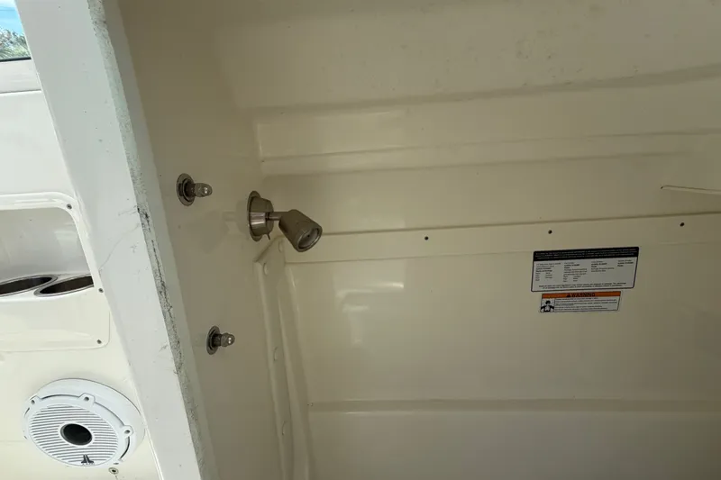 Slide: The Image of Interior view of a 2022 World Cat 230 DC boat, featuring a showerhead and speaker. - 51