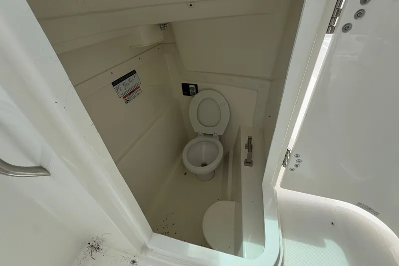 Slide: The Image of Interior view of a 2022 World Cat 230 DC boat's compact bathroom. - 50