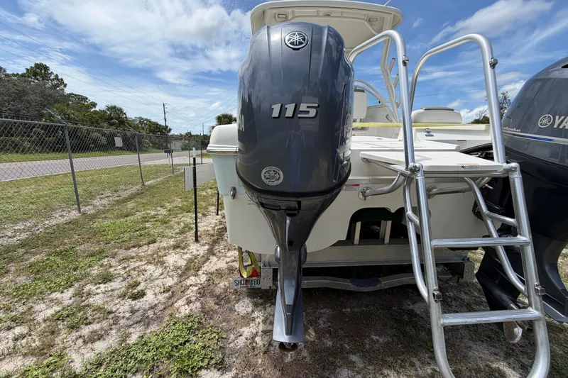 Slide: The Image of 2022 World Cat 230 DC boat with Yamaha 115 engine and ladder, parked outdoors. - 18
