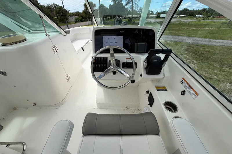 Slide: The Image of Helm of 2022 World Cat 230 DC boat with steering wheel and control panel. - 39